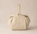 Beige handbag with 'Madam S' branding on a beige background