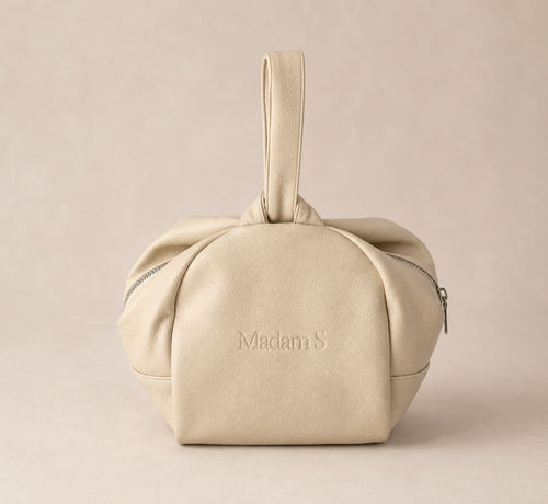 Beige handbag with 'Madam S' branding on a beige background